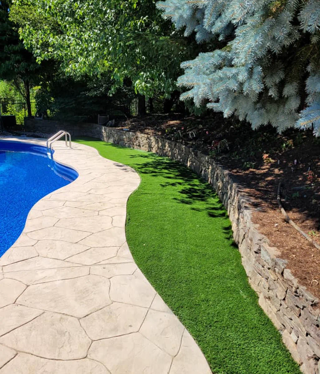 hardscape beside swimming pool and newly installed lawn and turf